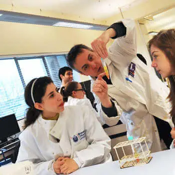 male lecturer explaining an experiment to two students in a science laboratory at СʪƵ London