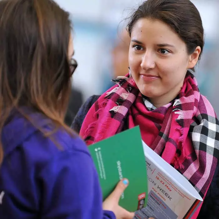 two women chatting at СʪƵ's career fair